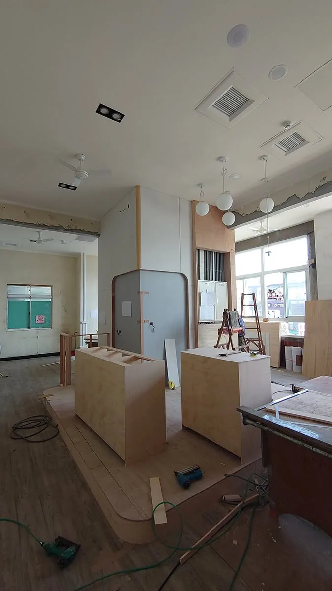 設計師與屋主在工地現場對照圖面討論的畫面
