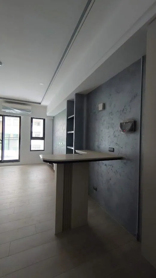 開放式公共空間完工實景,天花板保留裸露結構搭配灰階牆面與金屬燈具
